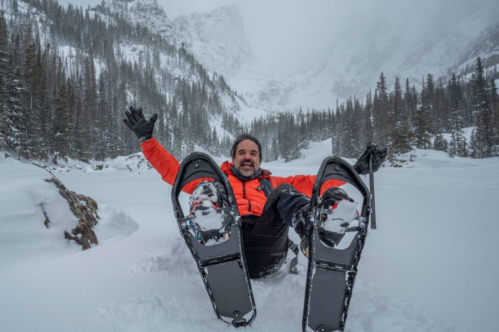 A man laying down in the snow on one of the best bikes in Telluride.